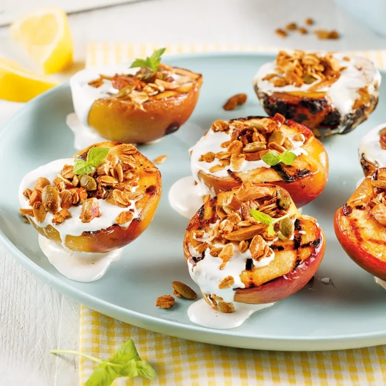 Pêches grillées avec guimauve sur une assiette, prêtes à être dégustées.