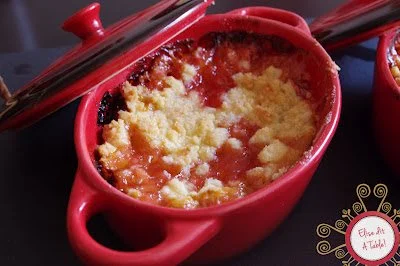 Crumble aux pêches chaud dans un plat en céramique, prêt à être dégusté.