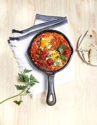 Recette de shakshuka aux œufs et tomates dans une poêle en fonte