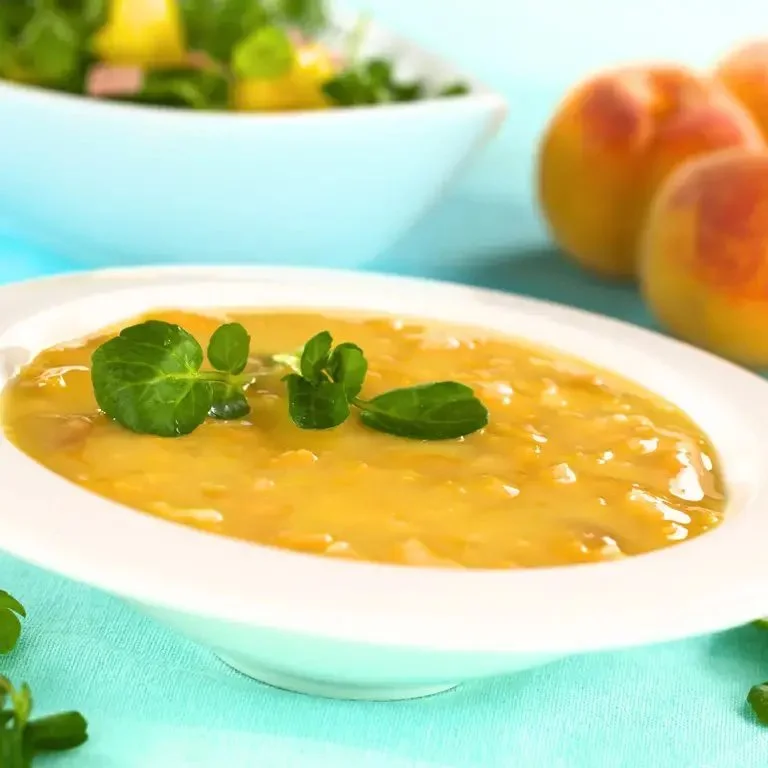 Bol de soupe de pêches garnie de fruits frais