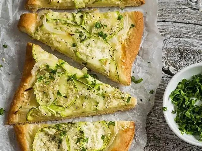 Pizzette courgette, oignon vert et fromage frais délicieusement garnie.