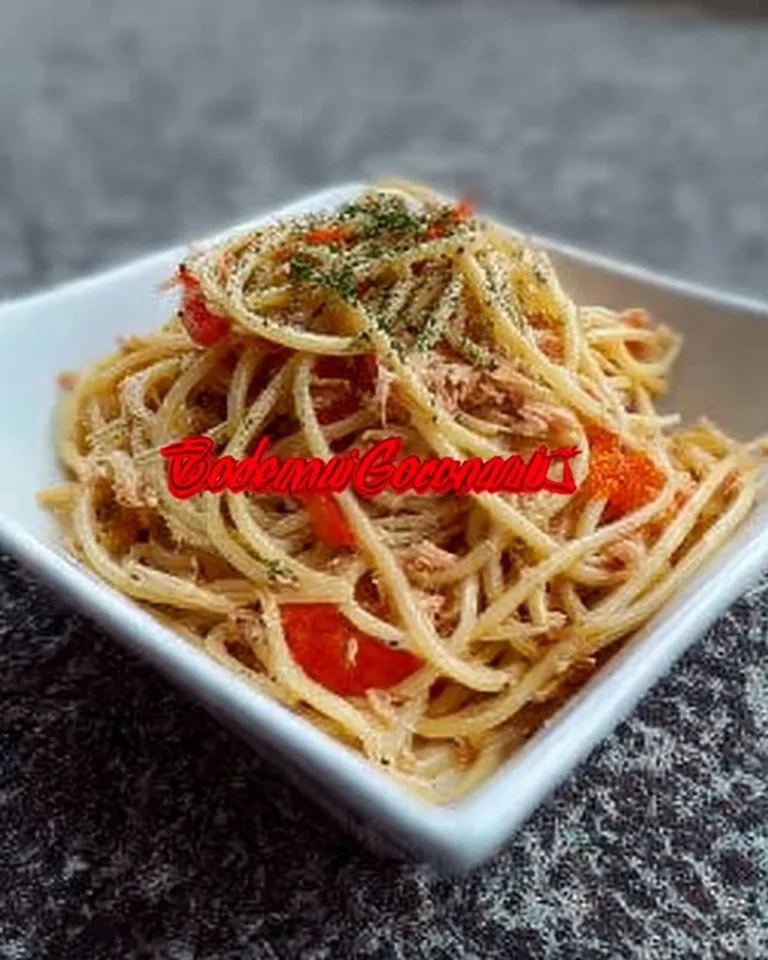 Spaghetti au thon garnis de tomates fraîches et d'herbes aromatiques.