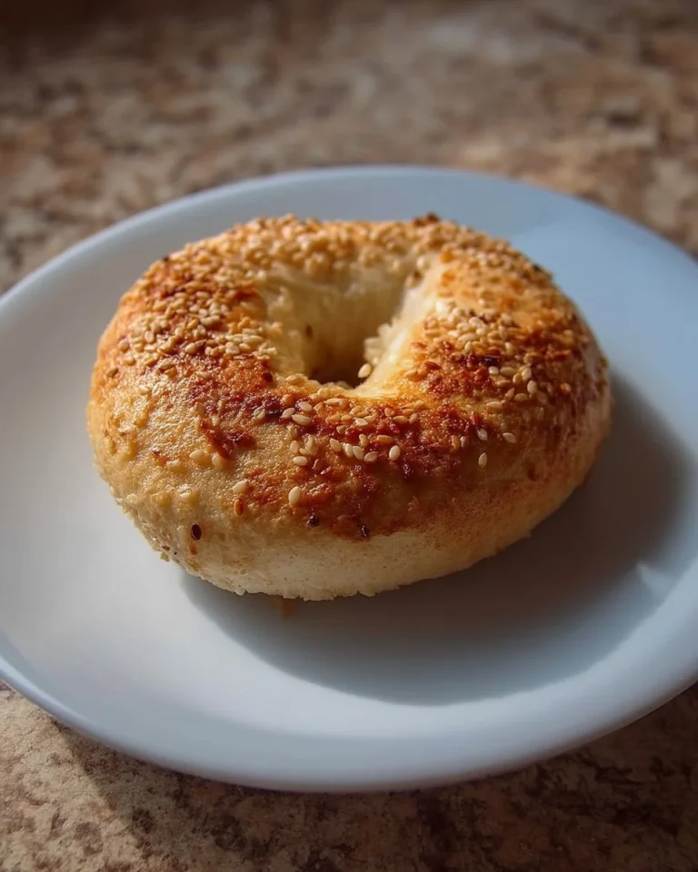 Bagels au sésame frais sur une nappe à carreaux.