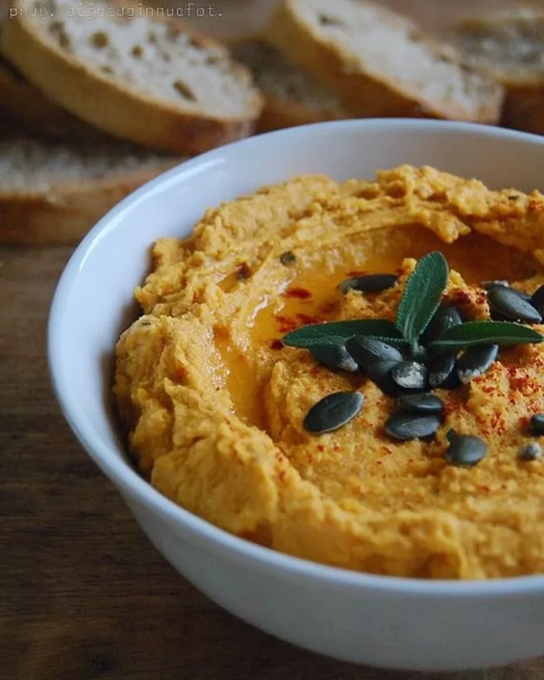 Bol de houmous aux carottes, garniture colorée et saine pour apéritif