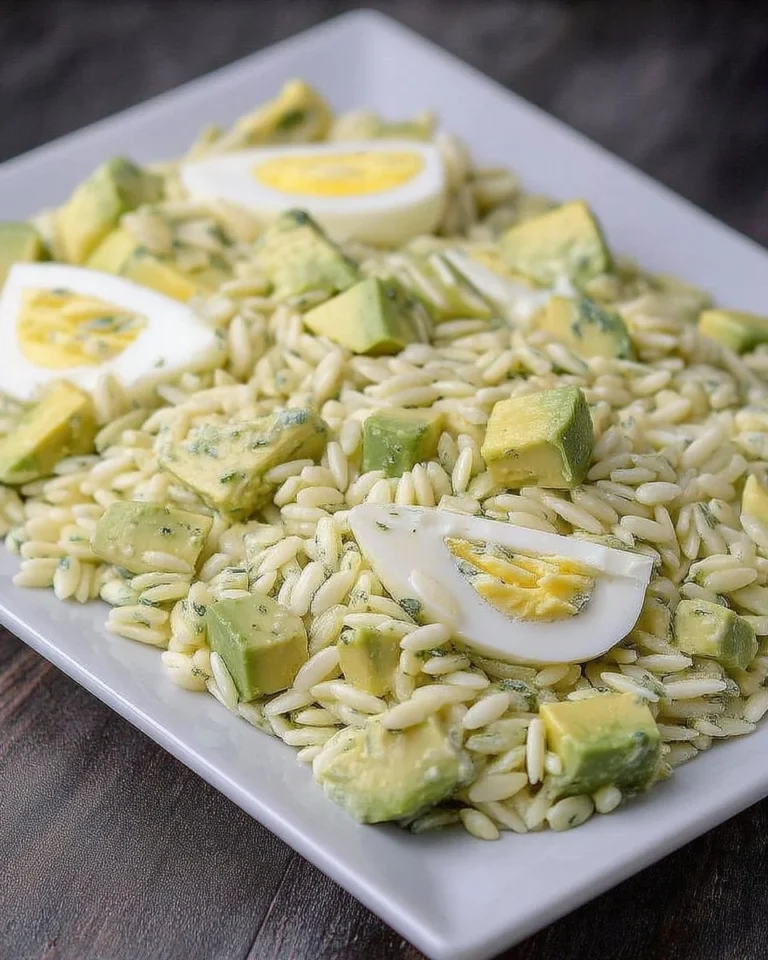 Salade d'orzo avec œufs pochés et avocat dans un bol.