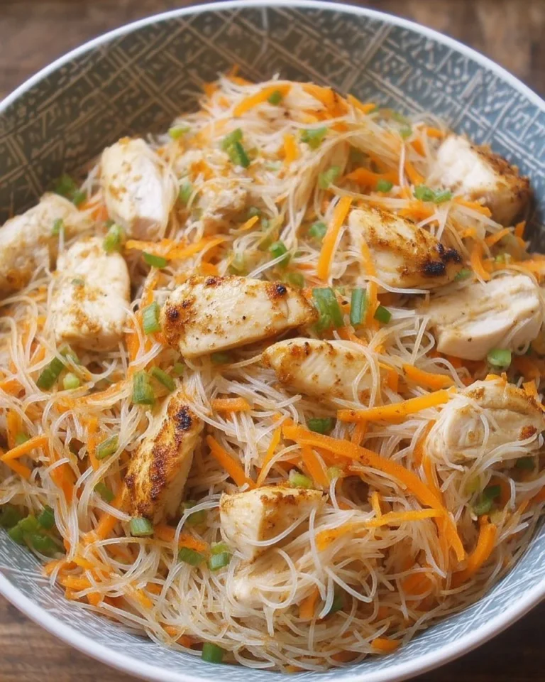 Salade de vermicelles au poulet garnie de légumes colorés et d'herbes fraîches.