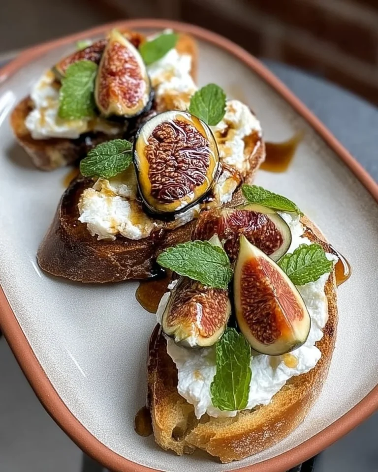 Bruschetta avec burrata, figues fraîches et miel balsamique sur une planche en bois