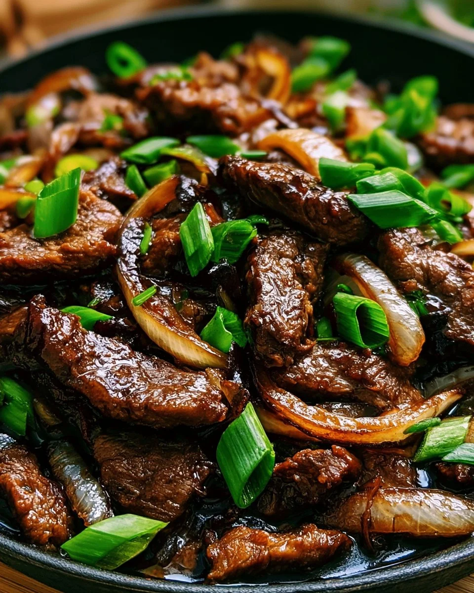 Boeuf caramélisé aux oignons et sauce soja dans une assiette